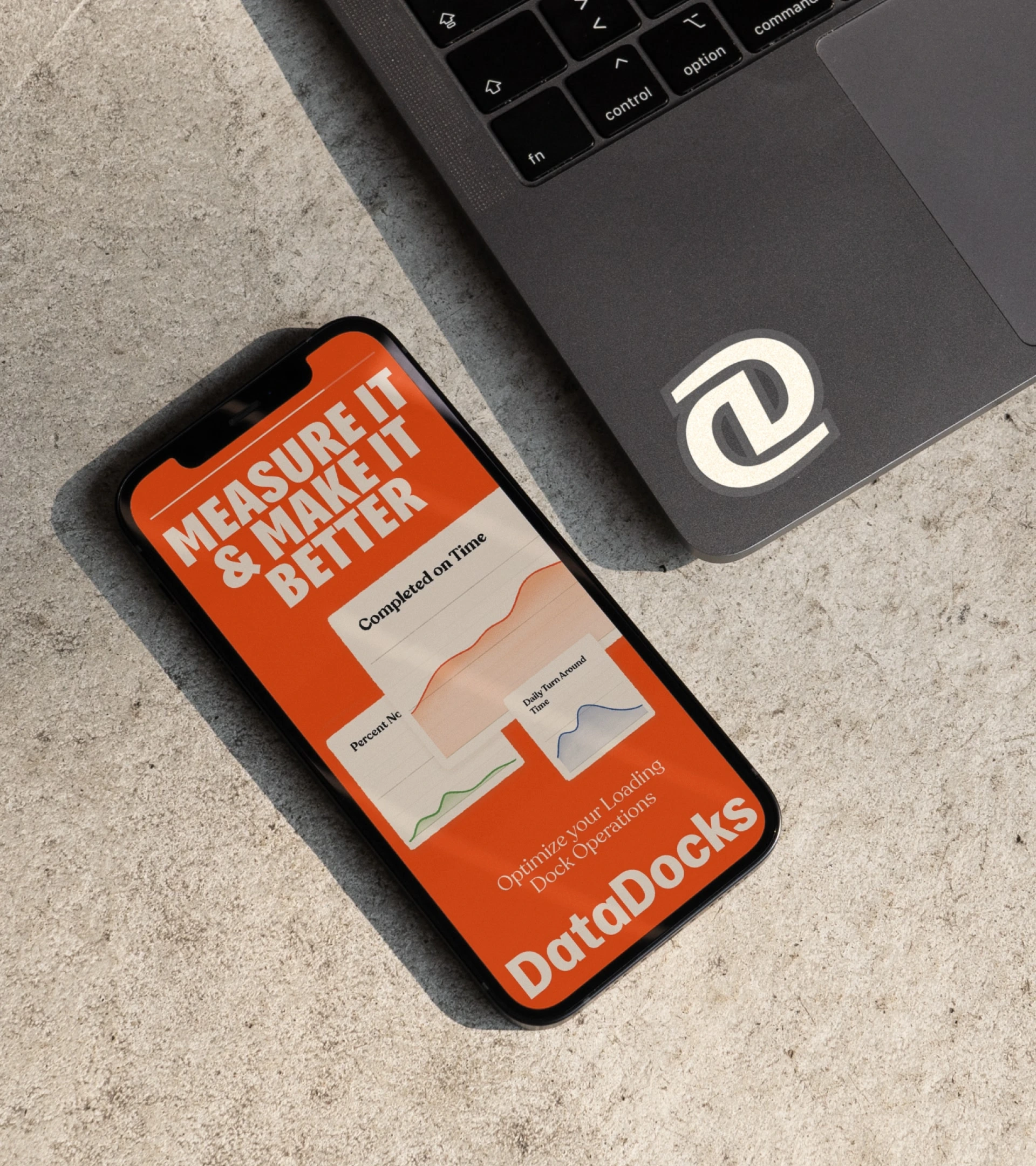 DataDocks mobile analytics screen beside a branded laptop sticker