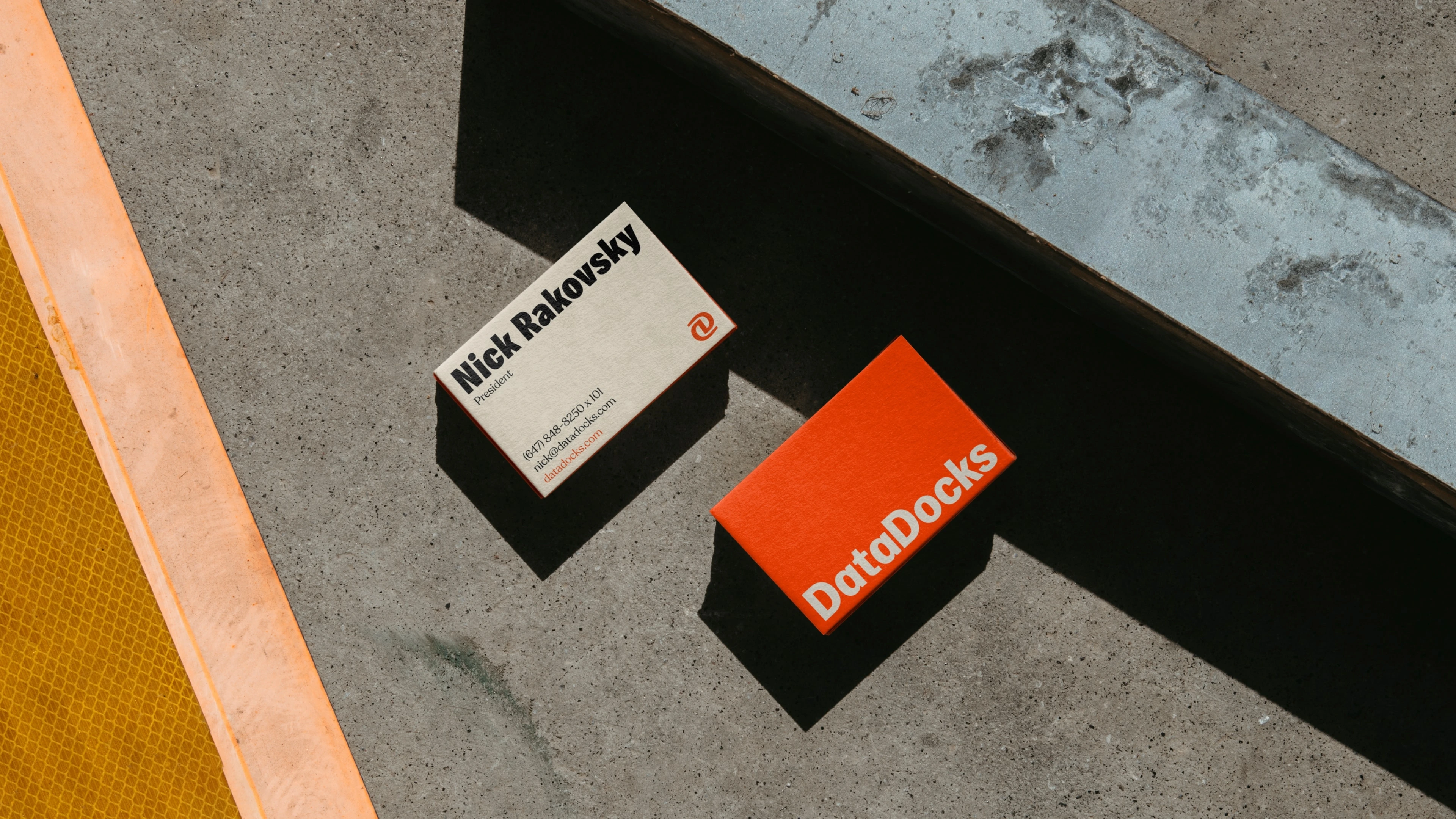 DataDocks business cards in orange, black, and off-white