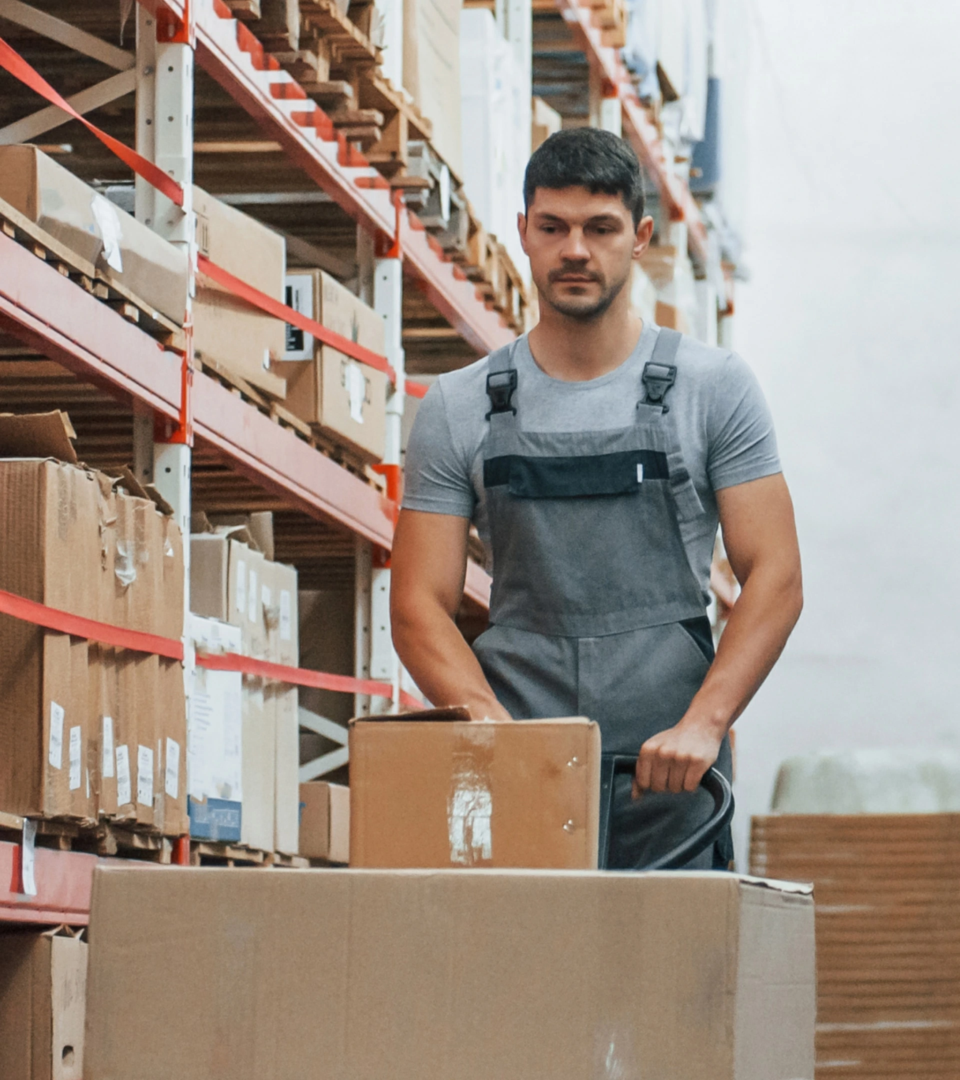 Warehouse worker moving boxes through a storage aisle