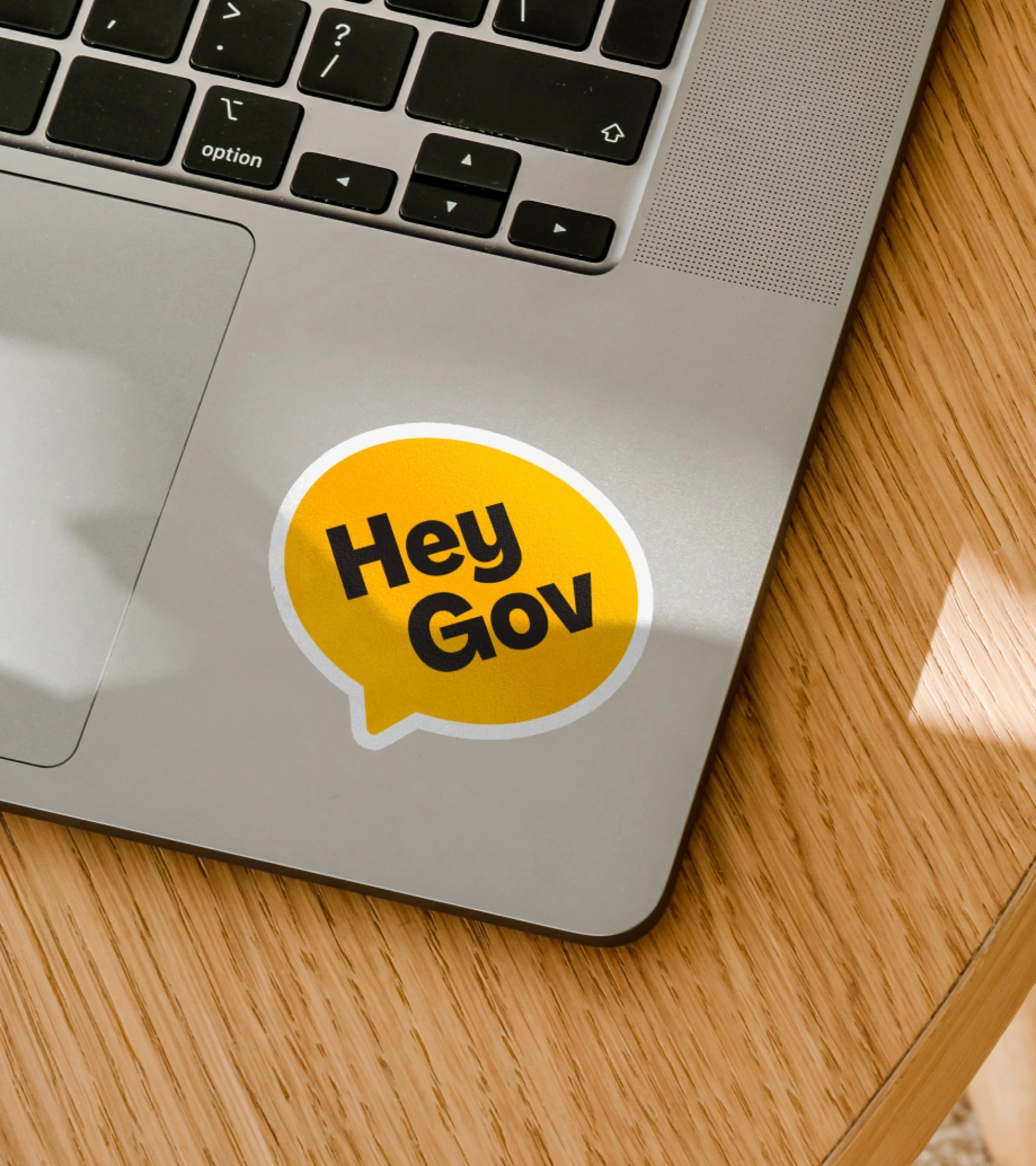 Yellow HeyGov logo sticker on a laptop
